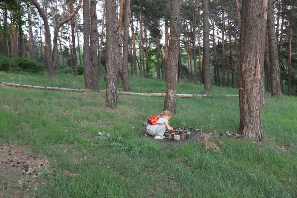 Menina perto do fogo na floresta . — Fotografia de Stock