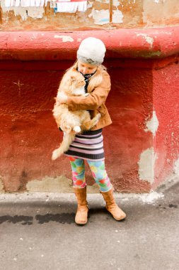 Eller de kırmızı kedi küçük kızla yakın çekim.