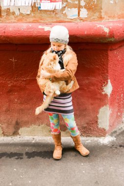 Eller de kırmızı kedi küçük kızla yakın çekim.