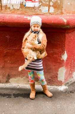 Eller de kırmızı kedi küçük kızla yakın çekim.