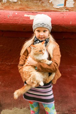 Eller de kırmızı kedi küçük kızla yakın çekim.