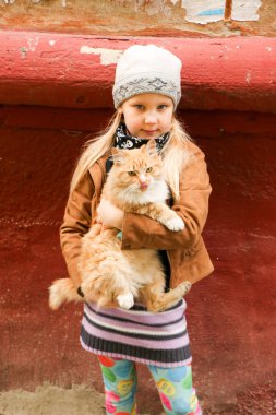 Eller de kırmızı kedi küçük kızla yakın çekim.