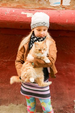 Eller de kırmızı kedi küçük kızla yakın çekim.