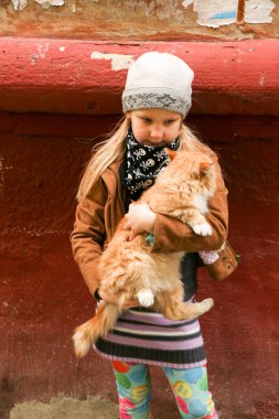 Eller de kırmızı kedi küçük kızla yakın çekim.