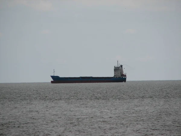 Ship far out to sea into haze transportation away from coast — Stock Photo, Image