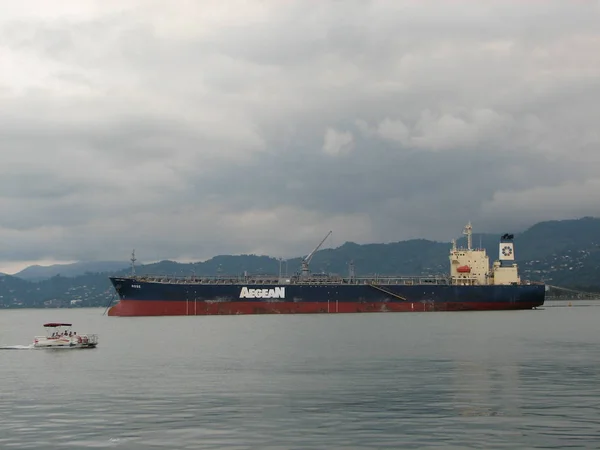 Ship far out to sea into haze transportation away from coast — Stock Photo, Image