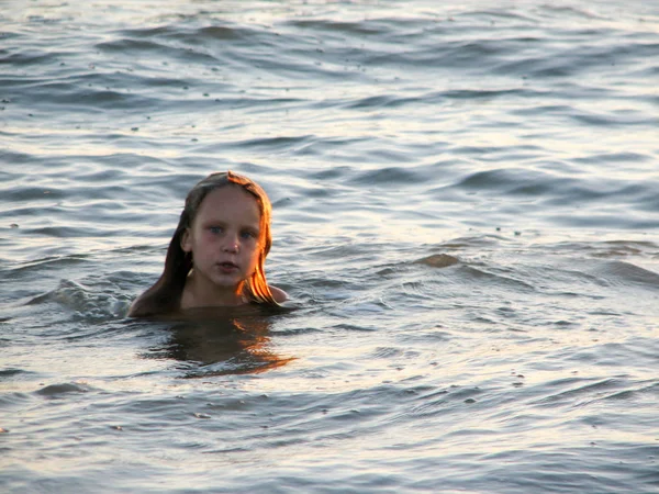 Klein meisje in de golven spelen — Stockfoto