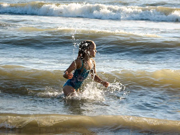 Niña jugando en las olas — Foto de Stock