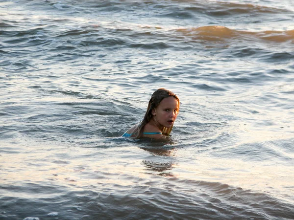 Klein meisje in de golven spelen — Stockfoto