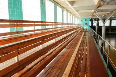 Spor salonunda boş ahşap banklar satırları.