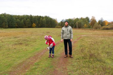 Bir alandaki kızıyla oynayan genç Baba