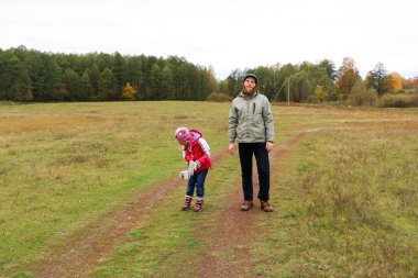 Bir alandaki kızıyla oynayan genç Baba