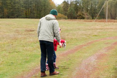 Bir alandaki kızıyla oynayan genç Baba
