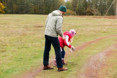 Bir alandaki kızıyla oynayan genç Baba