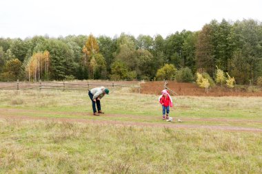 Bir alandaki kızıyla oynayan genç Baba