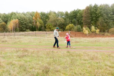 Bir alandaki kızıyla oynayan genç Baba