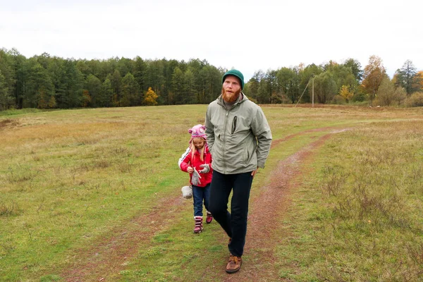 Jovem pai brincando com sua filha em um campo — Fotografia de Stock