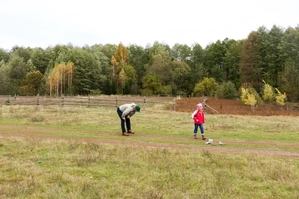 Jovem pai brincando com sua filha em um campo — Fotografia de Stock