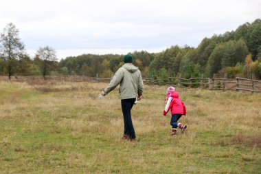 Bir alandaki kızıyla oynayan genç Baba