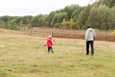Bir alandaki kızıyla oynayan genç Baba