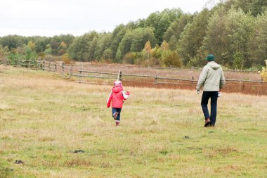 Bir alandaki kızıyla oynayan genç Baba