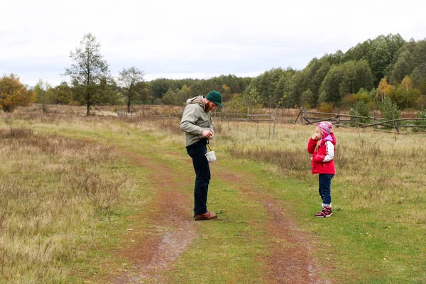 Jovem pai brincando com sua filha em um campo — Fotografia de Stock