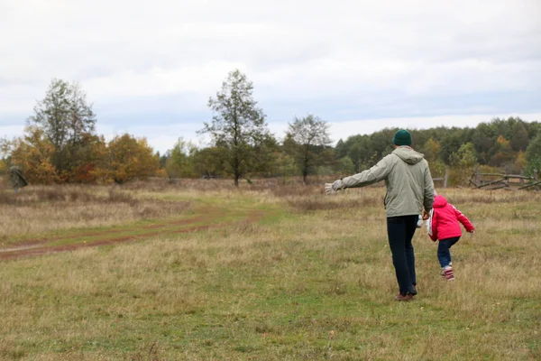 Jonge vader spelen met zijn dochter in een veld — Stockfoto