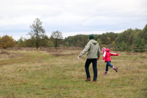 Jovem pai brincando com sua filha em um campo — Fotografia de Stock