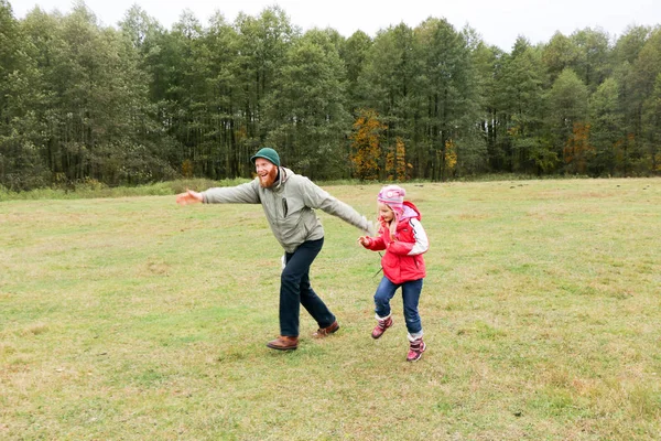 Jovem pai brincando com sua filha em um campo — Fotografia de Stock