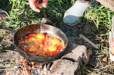 Çırpılmış yumurta tavası açık ateş üzerinde kömürler üzerinde kızarmış, bir açık ateşte pişirin