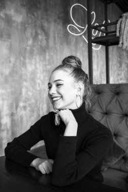 Siyah elbise giyen zarif sarışın kız bir kafede dinleniyor. Reklam, moda, ticari tasarım. Siyah elbiseli bir kız. Bir kafede güzel bir kız.