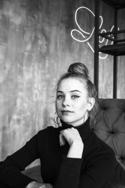 Menina loira elegante bonita vestindo um vestido preto é relaxante em um café. Publicidade, moda, design comercial.Menina em um café em um vestido preto. Menina bonita em um café . — Fotografia de Stock