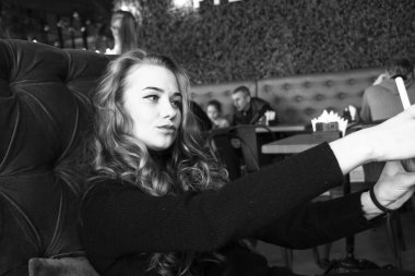 Tatmin olmuş güzel kız akıllı telefondan selfie çekiyor.