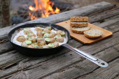 Üzüm salyangozları, akhatina, kırmızı bir tabakta, ham yiyecek, turşuluk ve lezzetli bir Burgundy salyangozu, midye, Fransız mutfağı olarak. Eski ahşap tahtaların ve ekmeklerin arkaplanını kapat