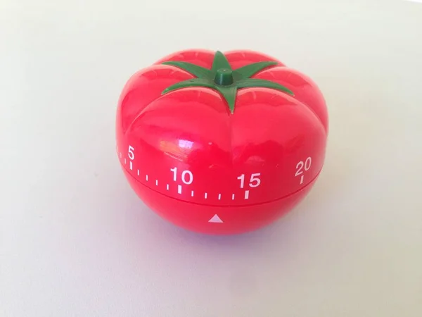 緑のディテールのポモドーロタイマー赤。テーブルの上にトマト。鮮やかで多角度の色. — ストック写真
