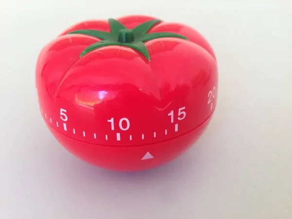 Pomodoro Timer rot mit grünen Details. Tomate auf dem Tisch. lebendige, vieleckige Farben. — Stockfoto