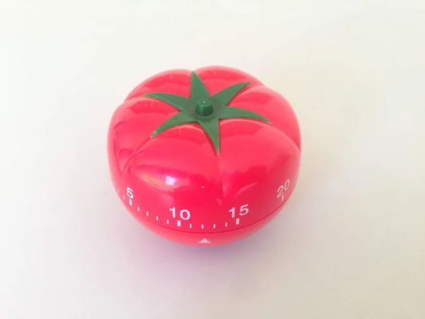 Yeşil detaylarla Pomodoro Zamanlayıcısı kırmızısı. Masada domates var. Canlı, çok açılı renkler. Stok Fotoğraf
