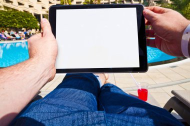 Tablet bir otelin havuzunda yanındaki adam. Bakış açısı