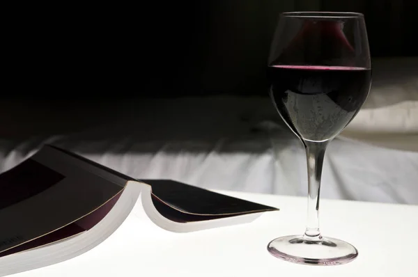 Boek, rode wijn, bed. 'S avonds ontspannen concept — Stockfoto