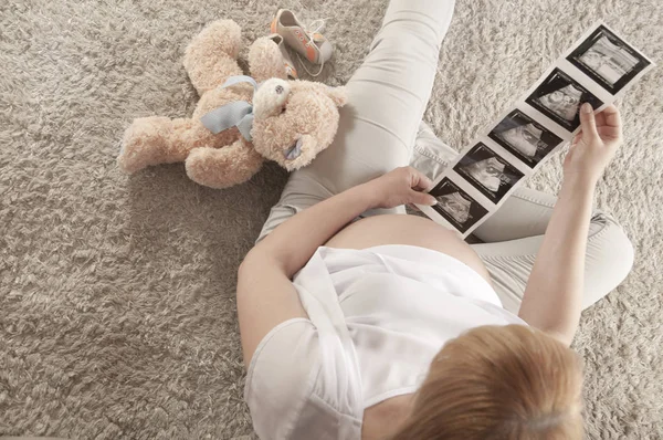 Těhotné ženy při pohledu na obrázky ultrasonografie — Stock fotografie