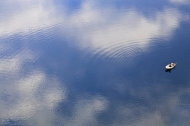 Balıkçı huzurlu suların bir teknede