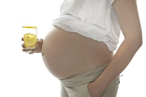 Bicchiere d'acqua e una donna incinta — Foto Stock