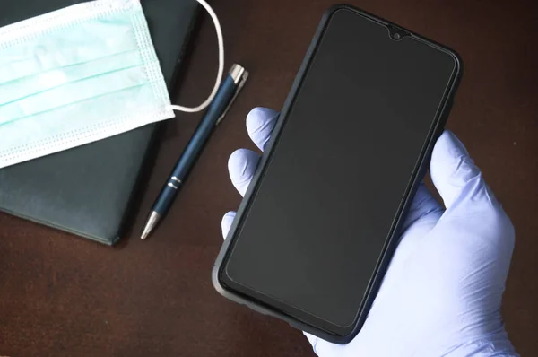 Guante Desechable Que Sostiene Teléfono Móvil Sobre Escritorio Negocio Durante —  Fotos de Stock