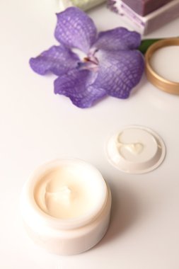 Natürmort krem kavanoz, çiçek ve sabun 