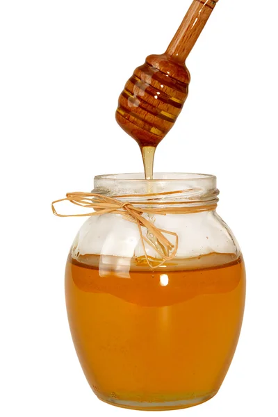 Вредный сладкий мед стекает в стеклянную банку . — стоковое фото