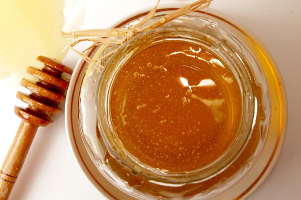 Skleněná dóza sladká lahodná medu a naběračka medu — Stock fotografie