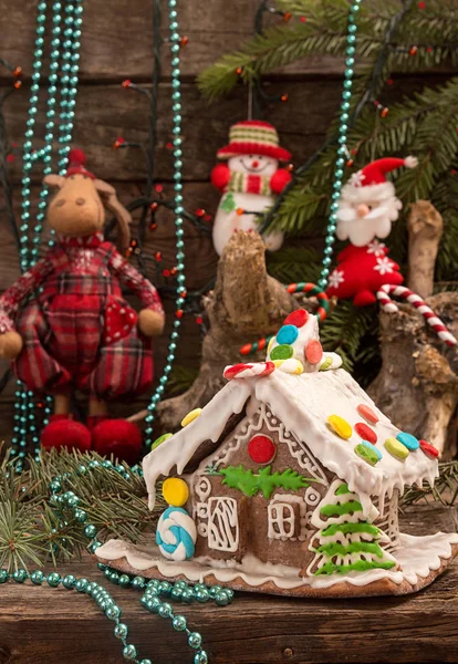 Christmas gingerbread house and holiday decorations on old woode