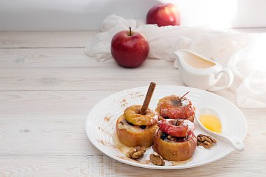 Ceviz ve beyaz tabakta bal pişmiş elma dolması