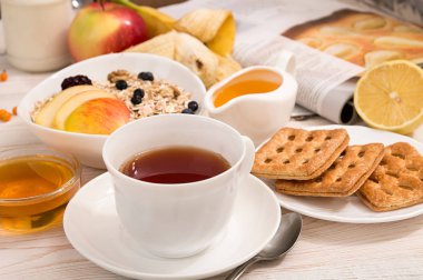 Sağlıklı kahvaltı. Müsli, fincan çay, bal, tanımlama bilgileri, elma ve