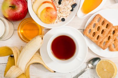 Sağlıklı kahvaltı. Müsli, fincan çay, bal, tanımlama bilgileri, elma ve